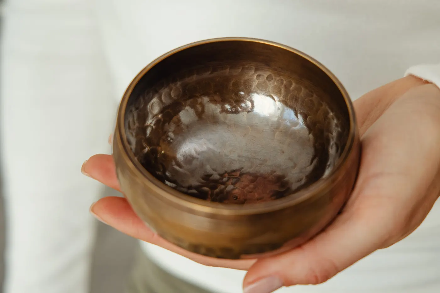 Two hands holding a Silent Mind singing bowl